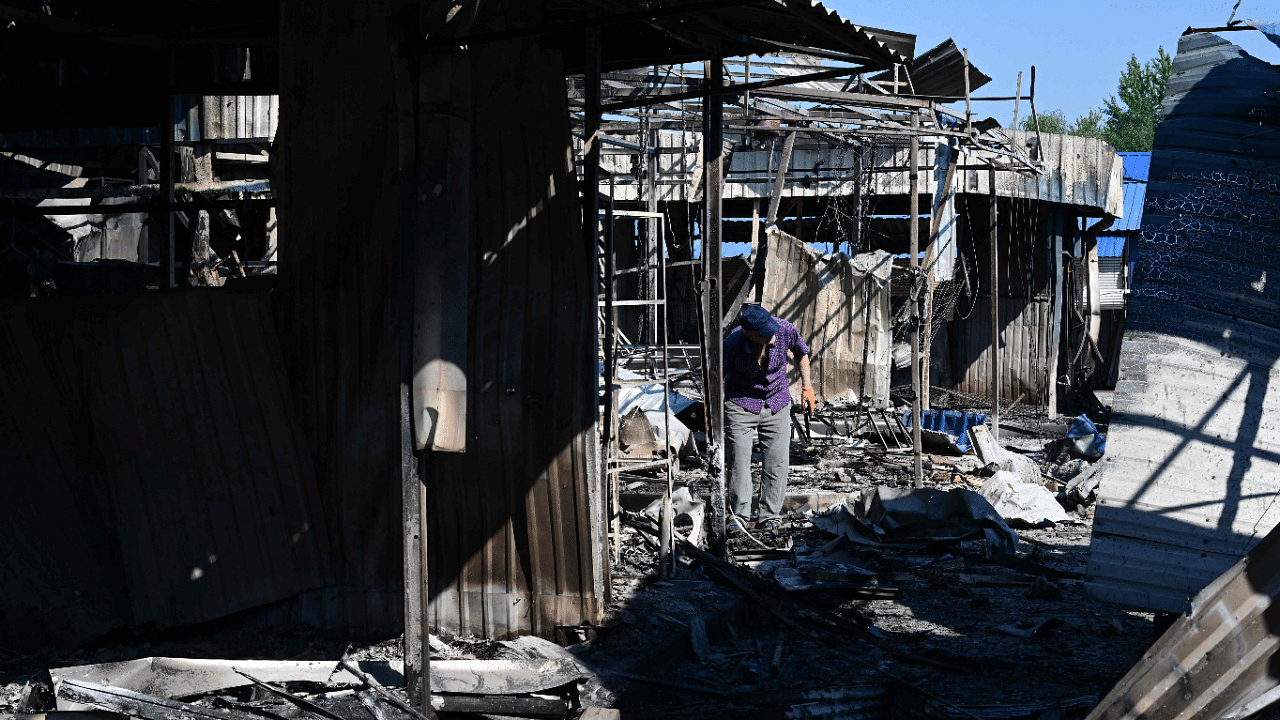 A man walks through the damage caused to the central market in Sloviansk by a suspected missile attack. Credit: AFP Photo
