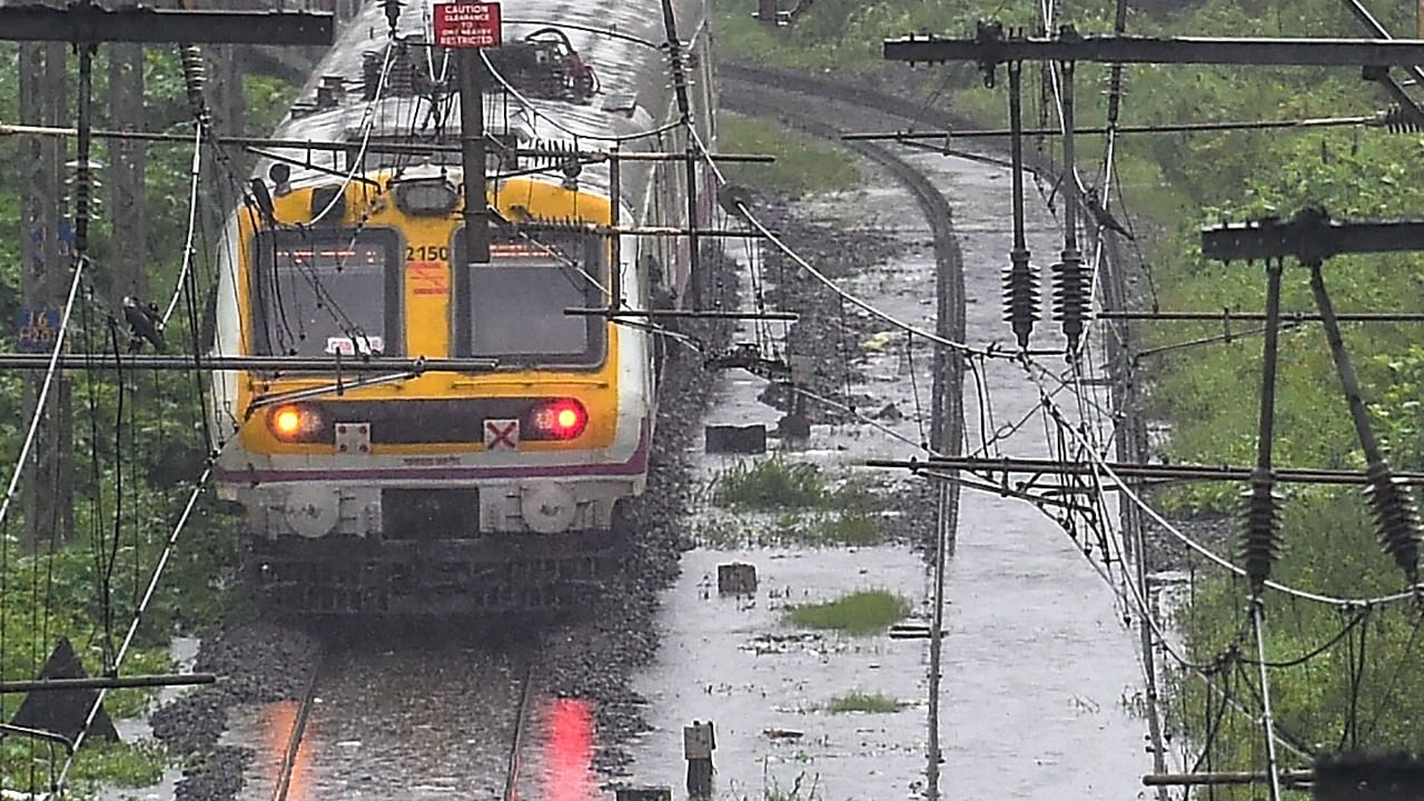 A local train runs on flooded tracks between Kurla and Tilak Nagar, following heavy monsoon rains. Credit: PTI Photo