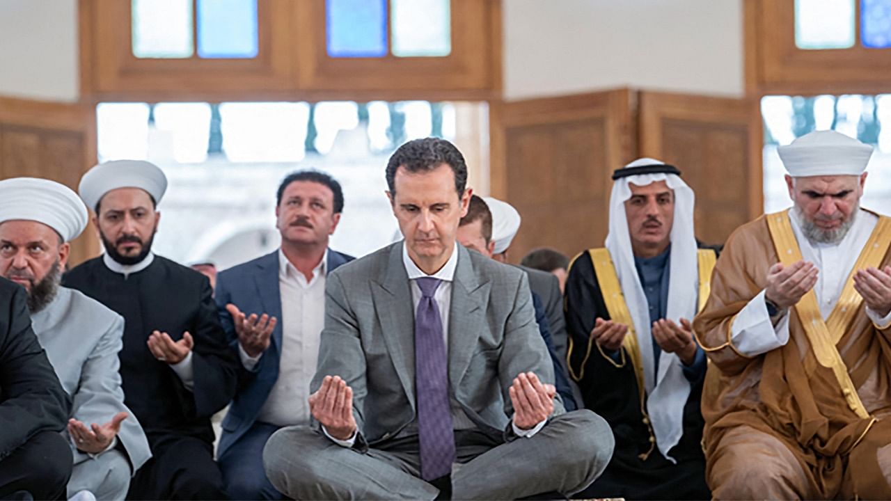 Syria's President Bashar al-Assad (C) attends the Eid al-Adha morning prayer at a mosque in the northern Syrian city of Aleppo. Credit: AFP Photo/SANA