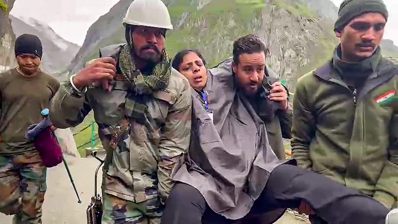 Army personnel rescue an injured pilgrim from the cloudburst affected areas near the Amarnath cave shrine. Credit: PTI Photo