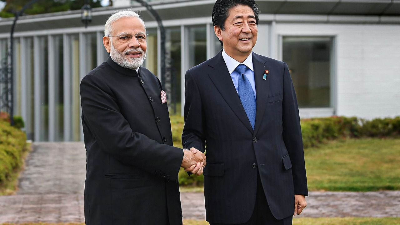 Former Japanese Prime Minister Shinzo Abe shakes hands with Prime Minister Narendra Modi. Credit: PTI Photo