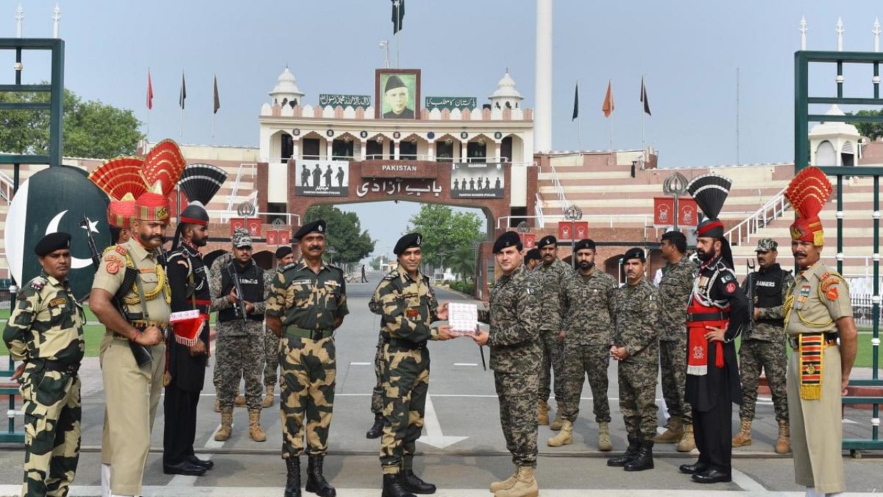 Border Security Force (BSF) Commandant Jasbir Singh presents sweets to Pakistani Rangers Wing Commander Aamir on the occasion of Eid al-Adha. Credit: PTI Photo