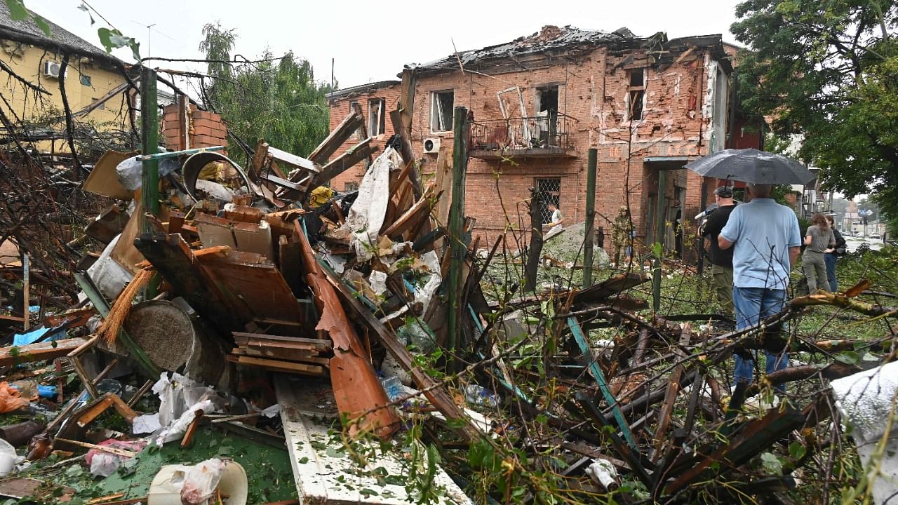 People look on at the ruins of a house destroyed as a result of a suspected missile strike in a residential area in Kharkiv. Credit: AFP Photo
