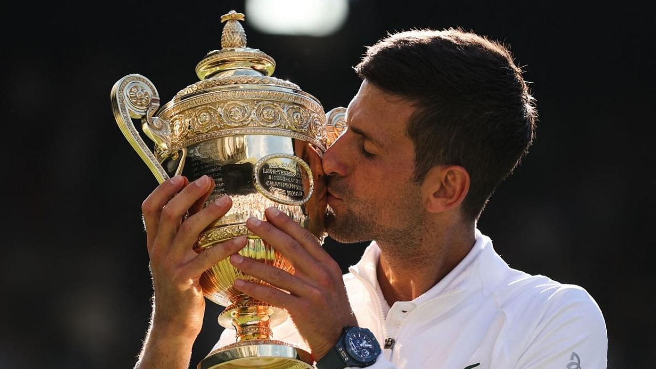 Serbia's Novak Djokovic kisses his trophy after defeating Australia's Nick Kyrgios during the men's singles final tennis match on the fourteenth day of the 2022 Wimbledon Championships. Credit: AFP Photo