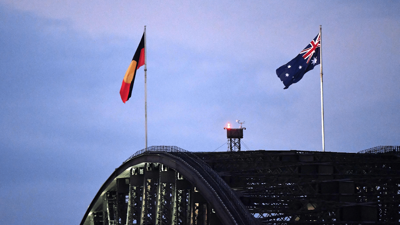 Australia's black, red and yellow Aboriginal flag (L) flies beside Australia's national flag over the Harbour Bridge in Sydney. Credit: AFP Photo