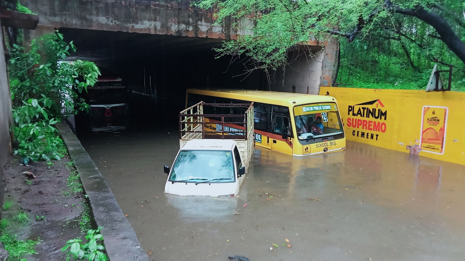  A school bus and other vehicles half submerged at Narendra Nagar, Nagpur. Credit: IANS Photo