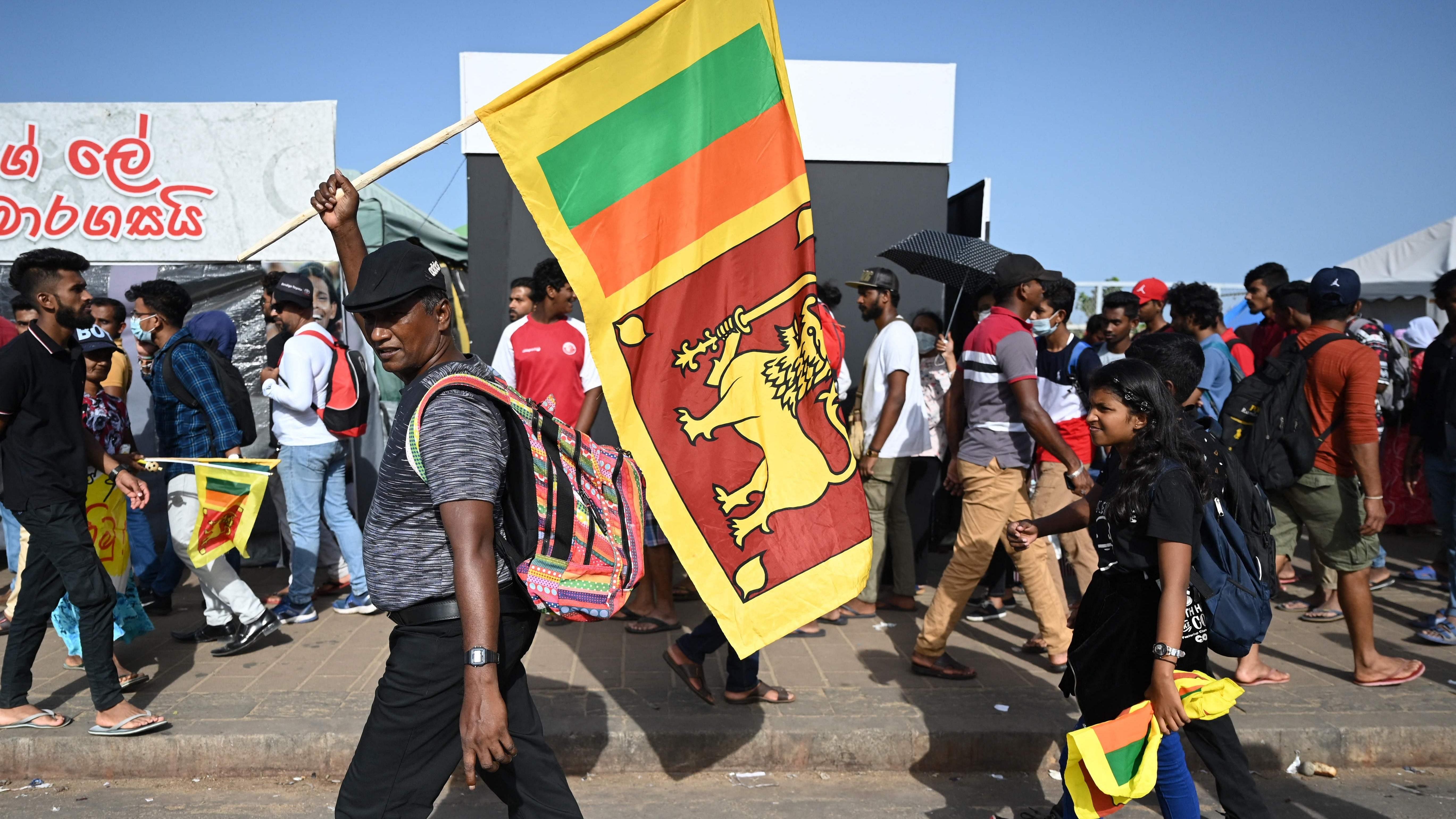 A man waves Sri Lanka's national flag outside presidential secretariat in Colombo. Credit: AFP Photo