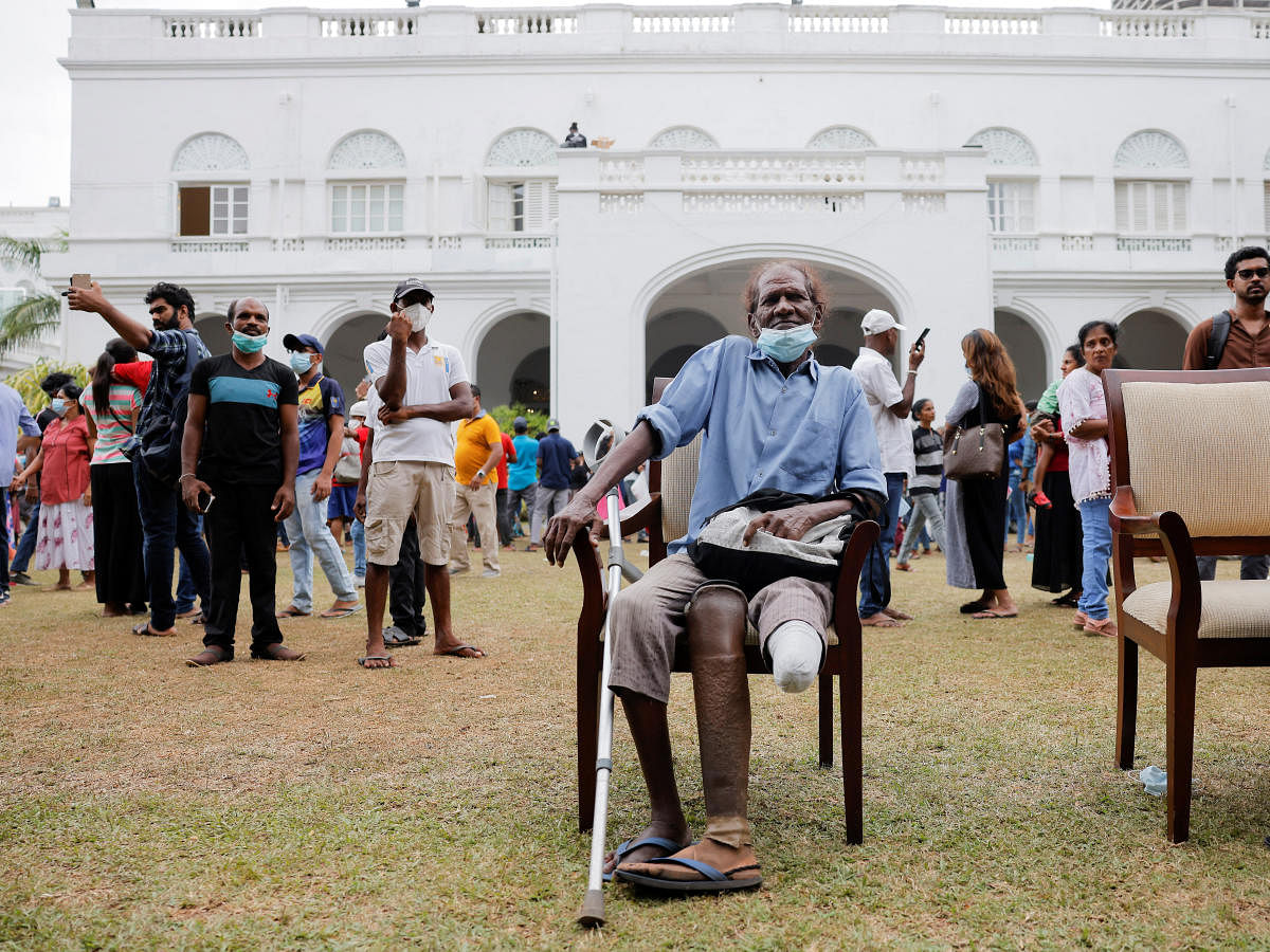 A man poses for photographs in the garden of the President's house after demonstrators entered the building, after President Gotabaya Rajapaksa fled, amid the country's economic crisis, in Colombo. Credit: Reuters Photo