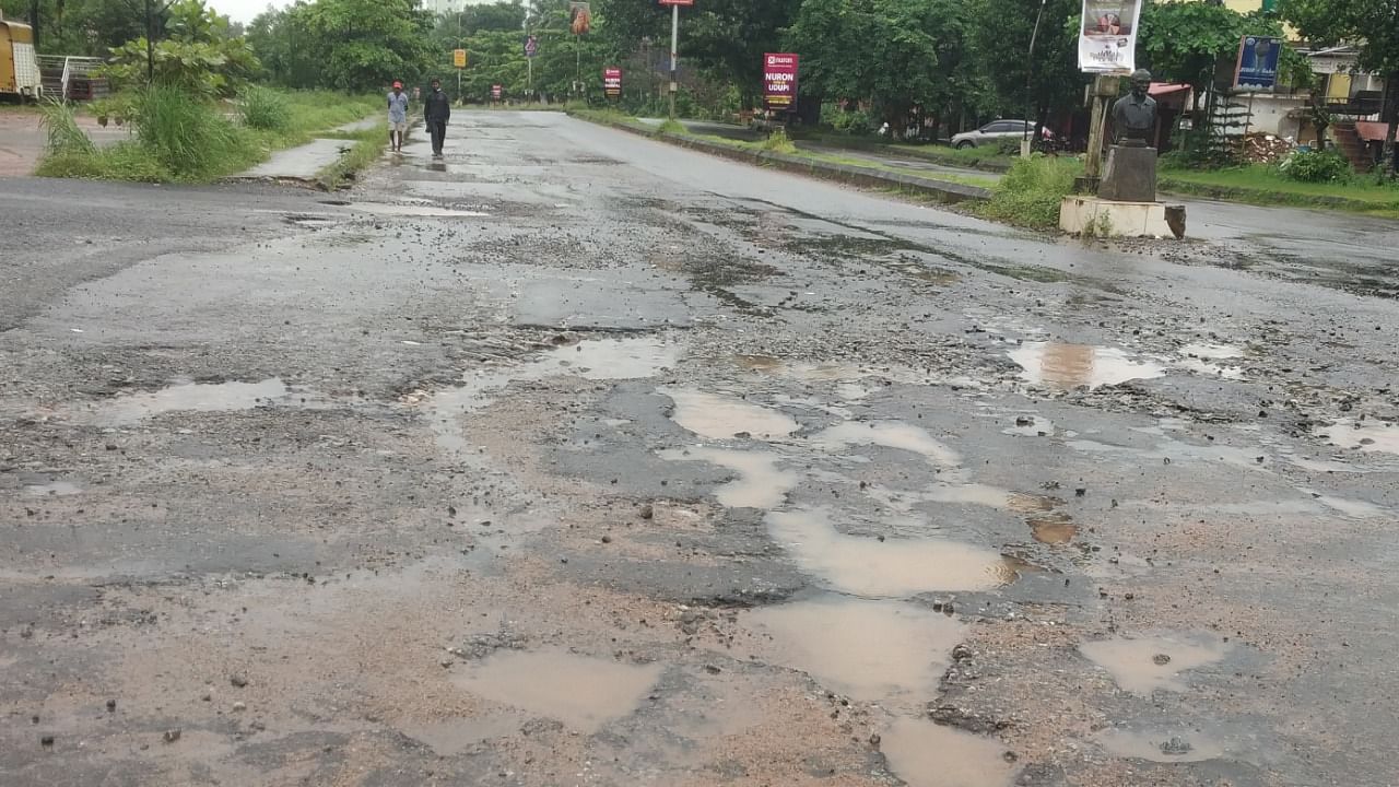 A view of potholes on the stretch at Ambagilu. Credit: DH Photo