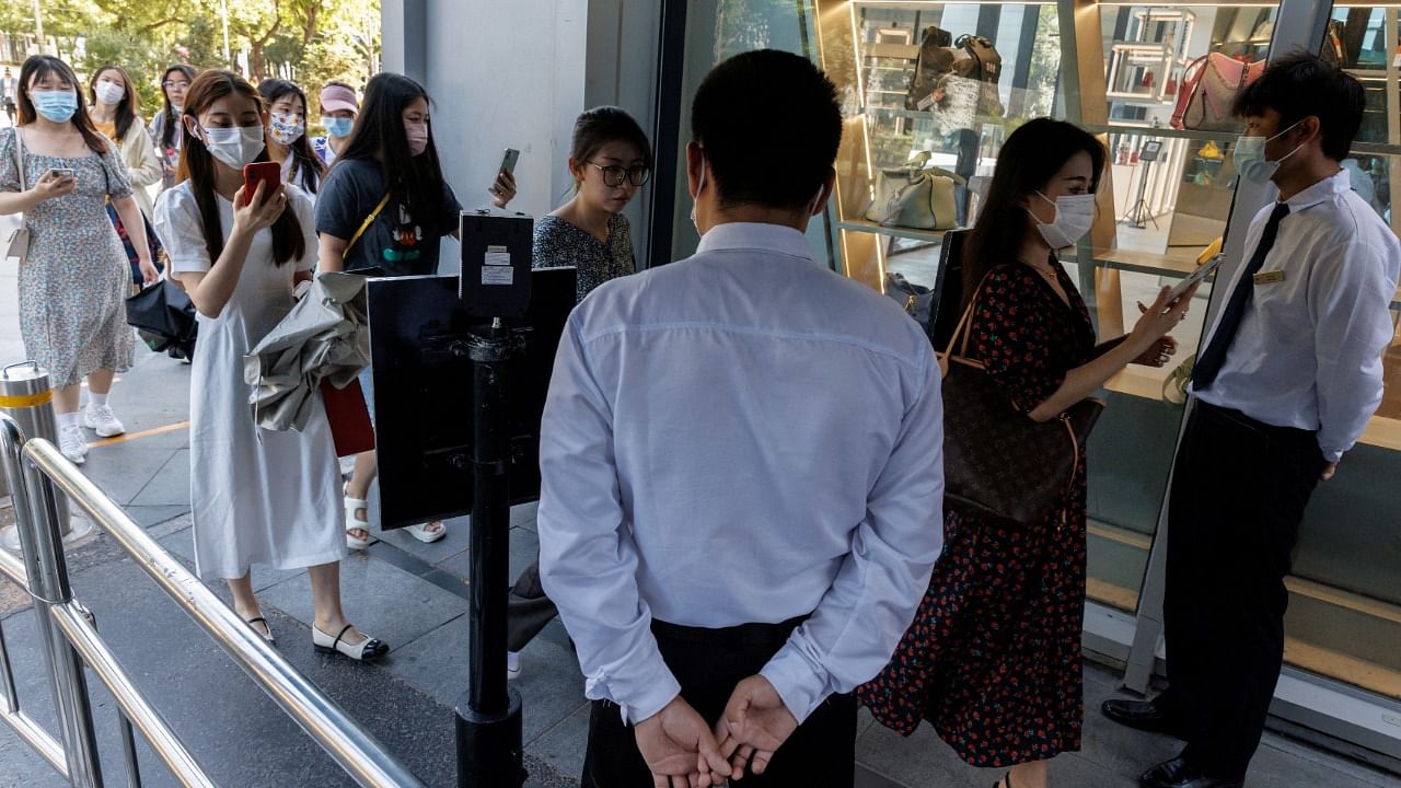 Security guards check the health code app of people entering a business area before office hours in Beijing. Credit: Reuters photo
