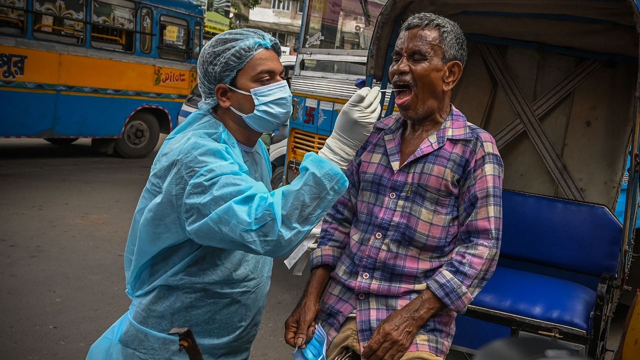 Health workers collect swab samples from commuters for Covid-19. Credit: AFP Photo