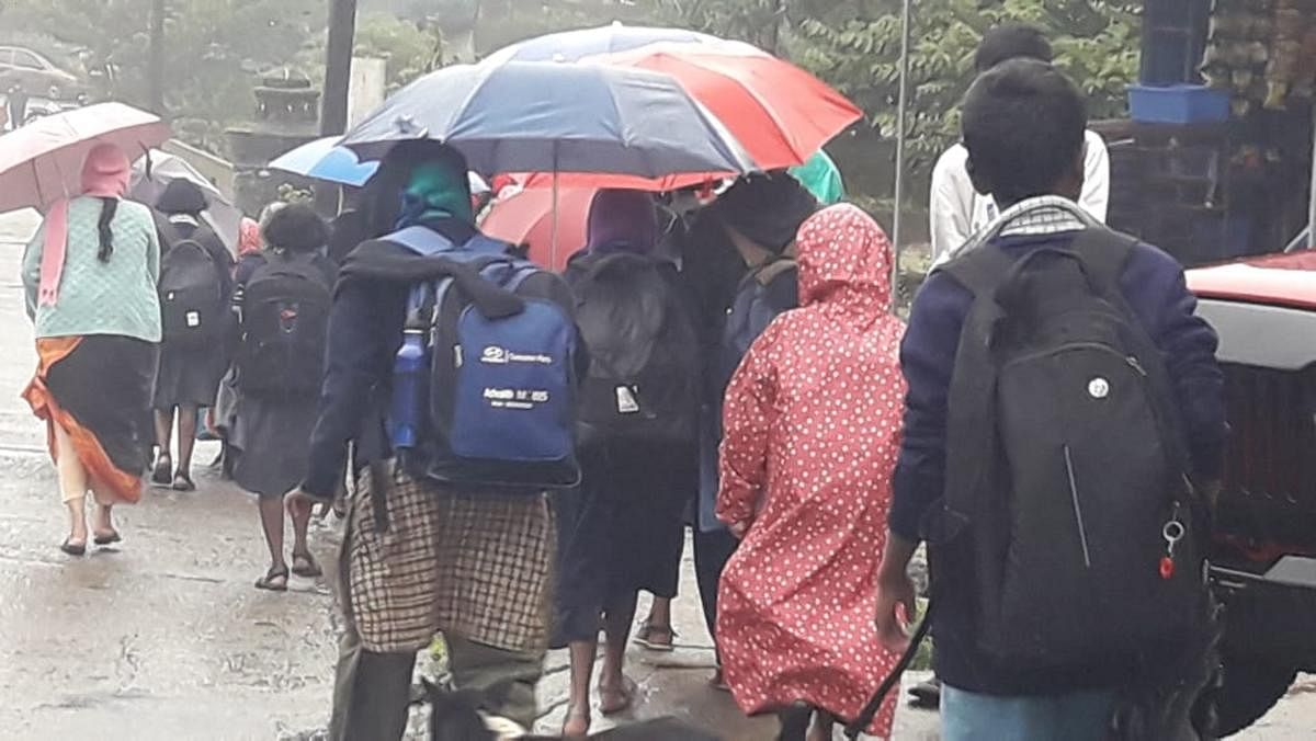 Students go to school amid cold breeze and heavy rainfall. Credit: DH Photos / Rangaswamy