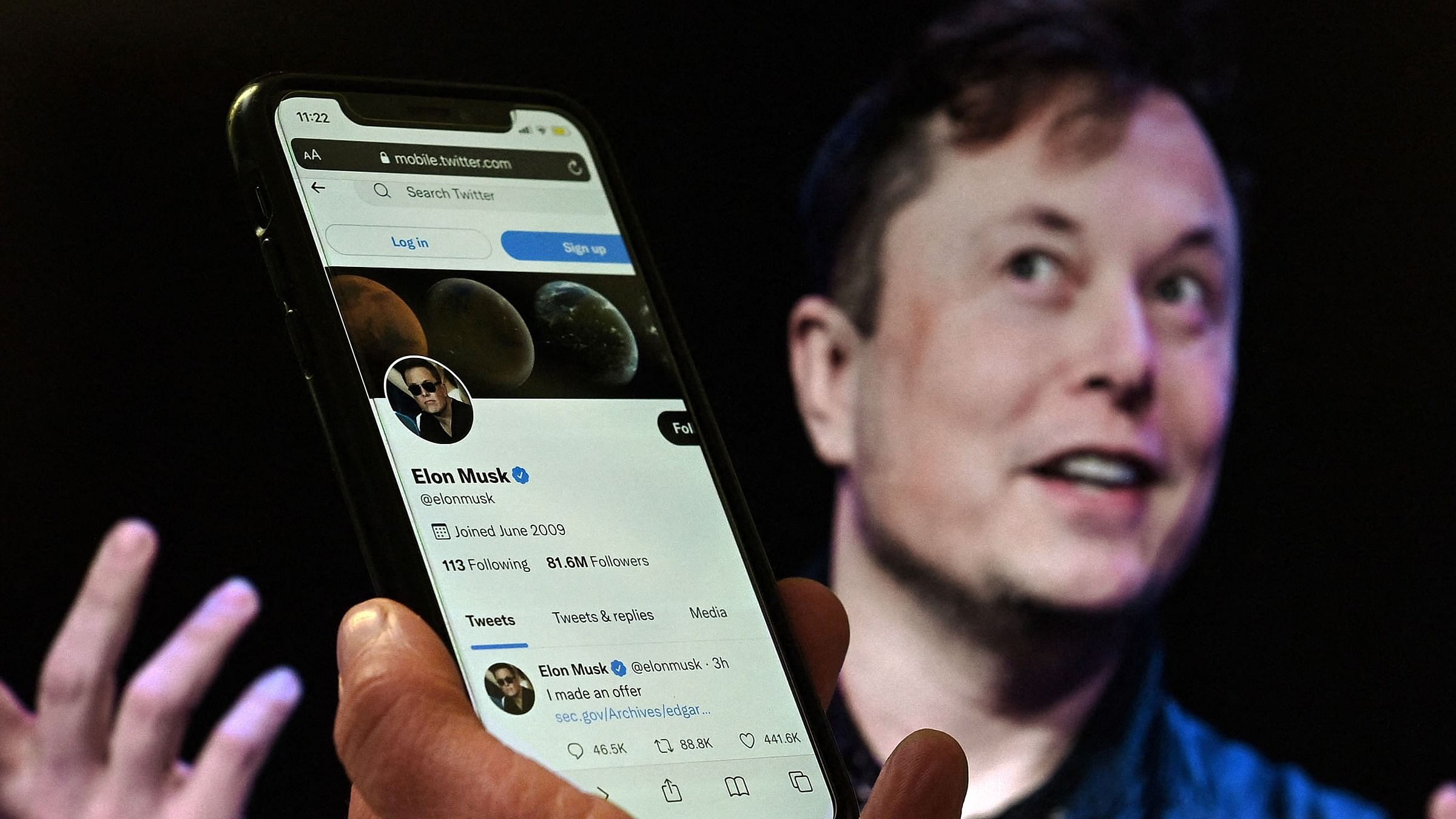 In this file photo illustration, a phone screen displays the Twitter account of Elon Musk with a photo of him shown in the background. Credit: AFP Photo