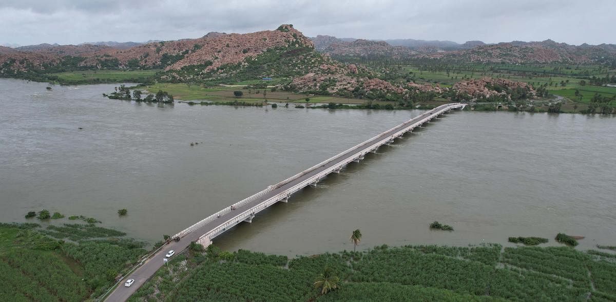 River Tungabhadra flows above the danger level under Bukkasagara-Gangavathi bridge near Hosapete on Friday. As much as 1.50  lakh cusec of water was released into the river from the Tungabhadra dam in the day. Credit: DH Photo/Rachaiah S Sthavarimutt