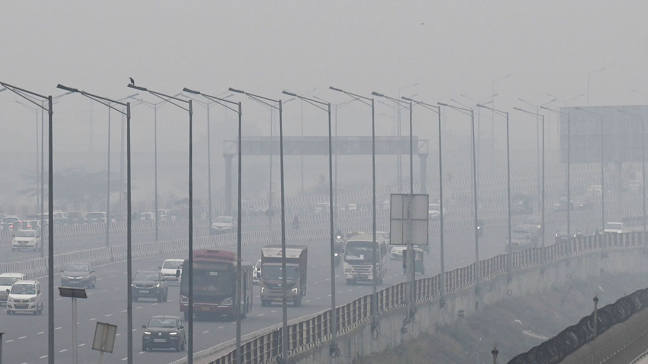 People commute along a street amid smoggy conditions in New Delhi on December 2, 2021. Credit: AFP File Photo