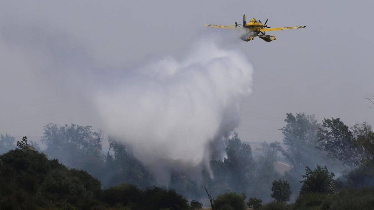 A plane tackles a wildfire, during the second heatwave of the year, in the vicinity of Tabara, Spain, July 19, 2022. Credit: Reuters Photo