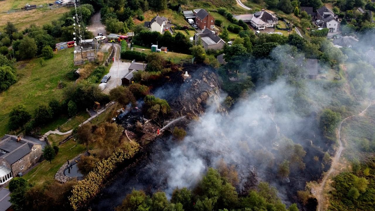 Firefighters tackle a grass fire during the heatwave in Mow Cop, Staffordshire, Britain. Credit: Reuters Photo