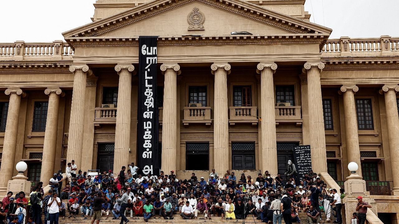 Demonstrators watch a public screen as voting begins to elect the new president at the parliament, amid the country's economic crisis, in Colombo, Sri Lanka. Credit: Reuters Photo