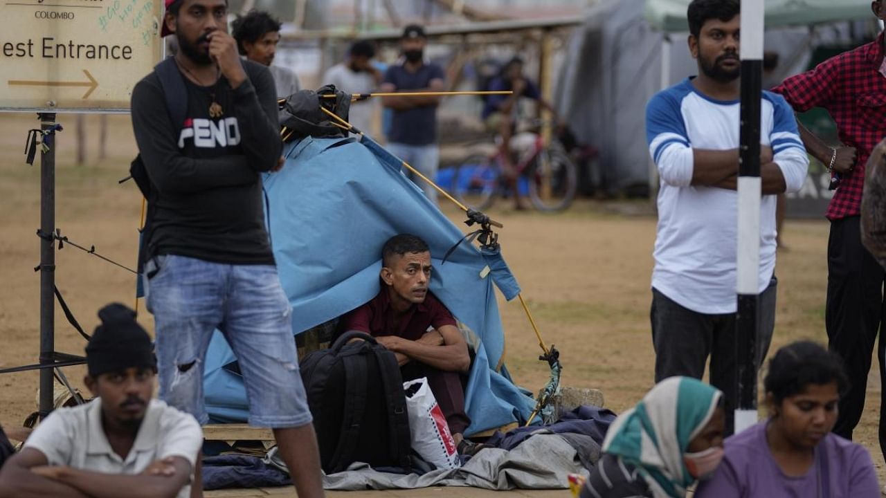 Protesters wait and watch troops stand guard following an eviction of protesters from the presidential secretariat in Colombo, Sri Lanka, Friday, July 22, 2022. Credit: AP Photo