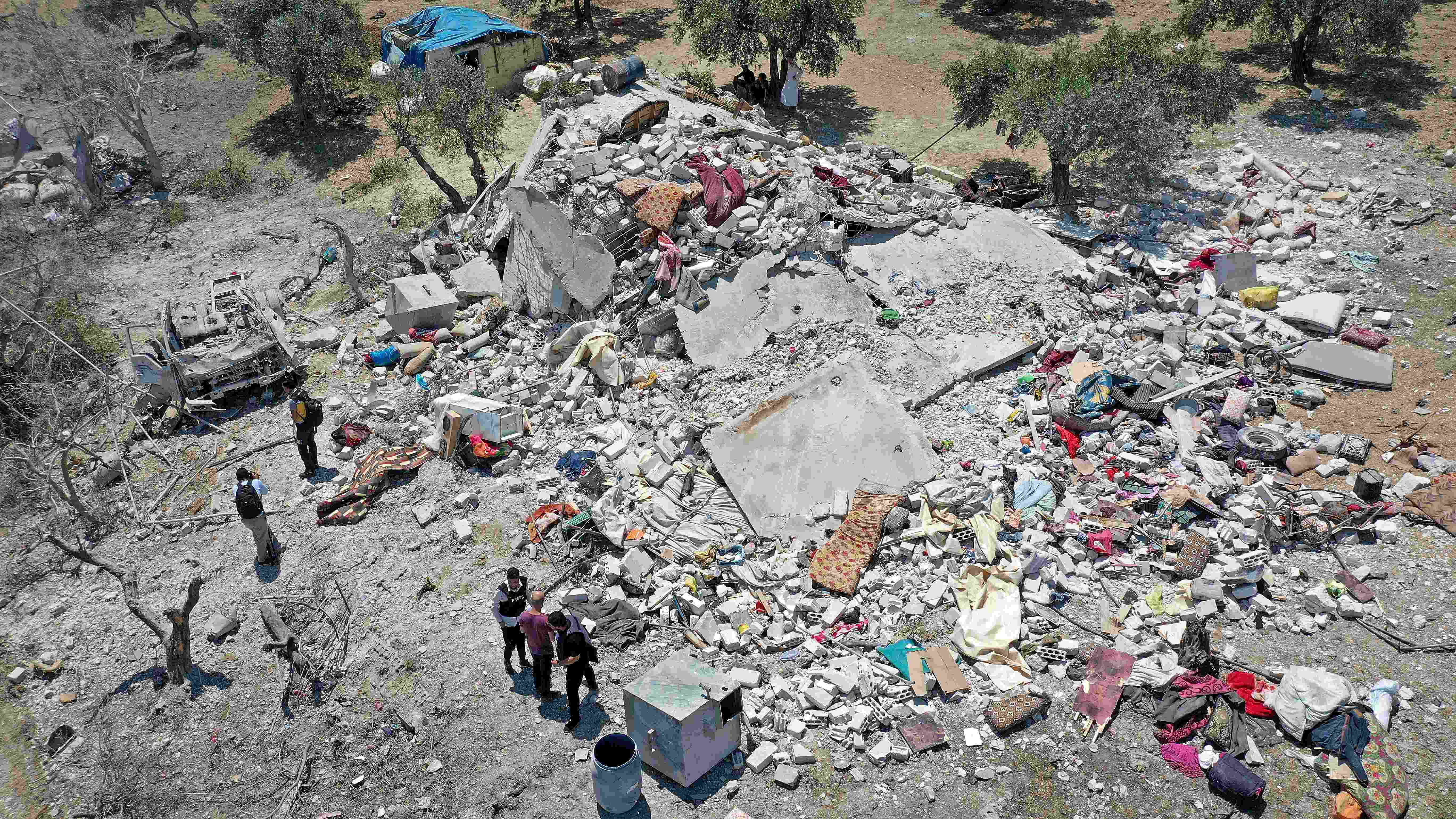 An aerial picture shows Syrians around the rubble of a house following a Russian air strike. Credit: AFP Photo