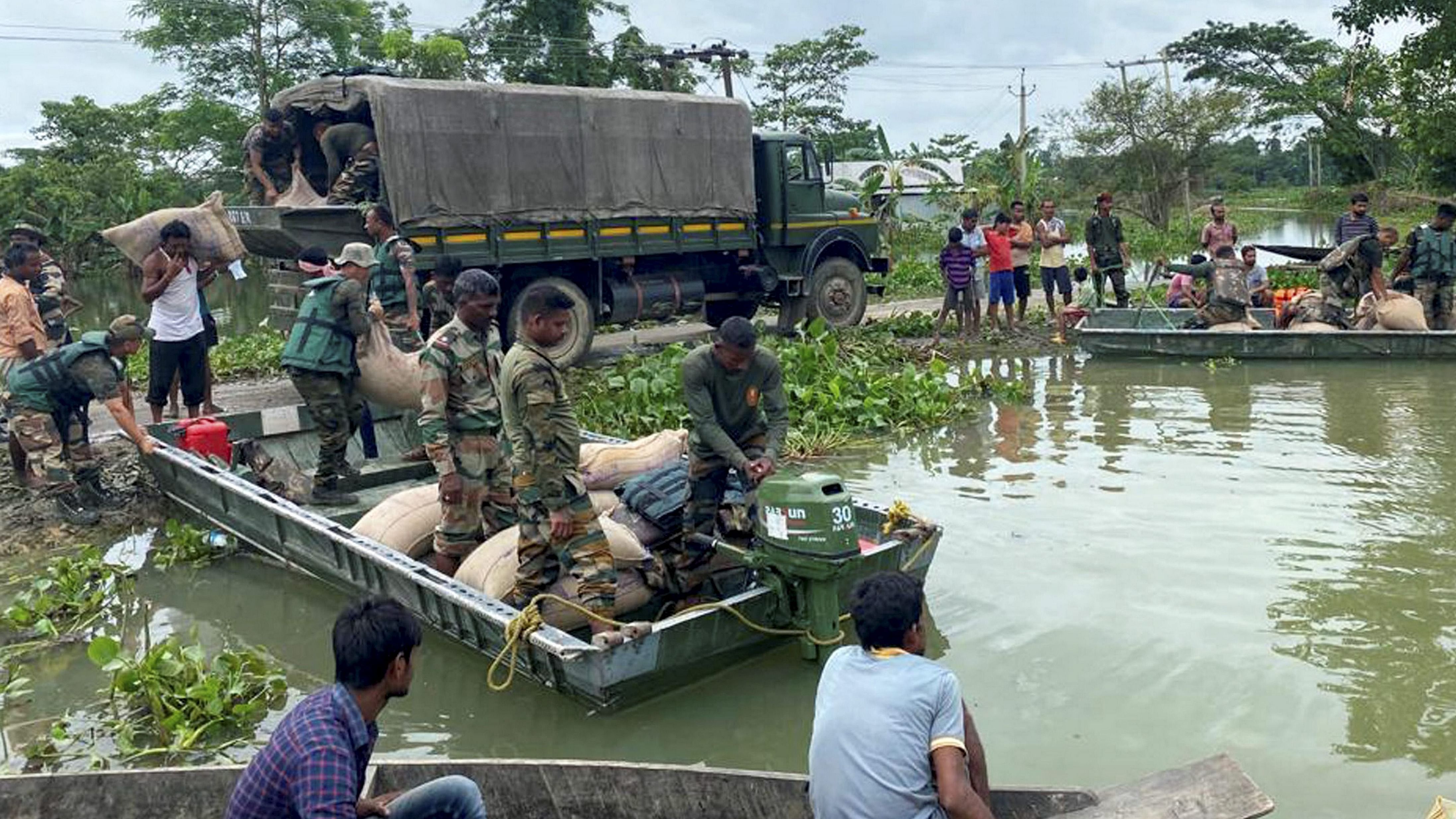 Indian Army's Assam Rifles personnel distribute relief material to residents of a flood-affected area, in Silchar. Credit: PTI Photo