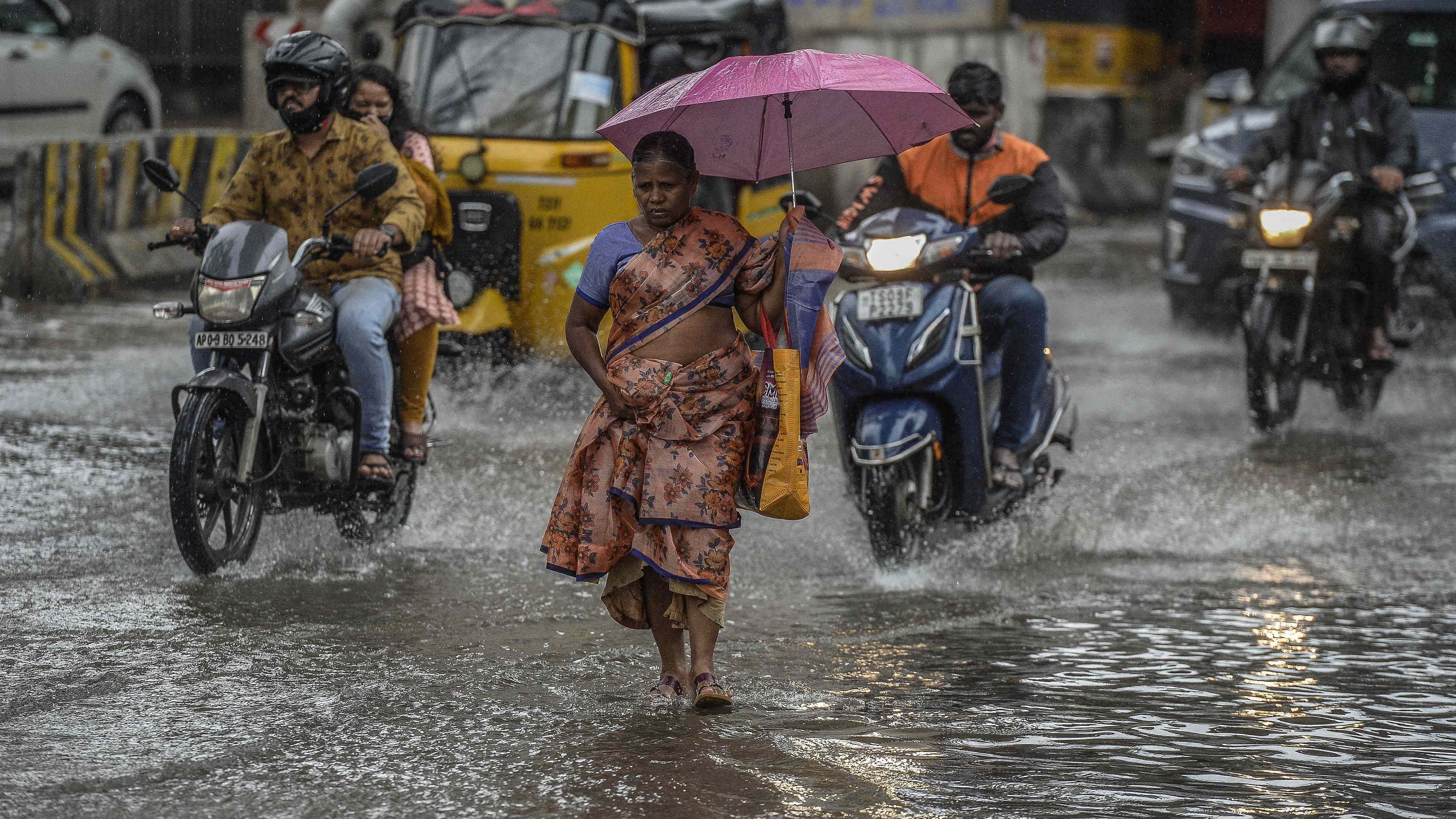 Commuters make their way along a waterlogged street during monsoon rainfall in Hyderabad. Credit: AFP Photo