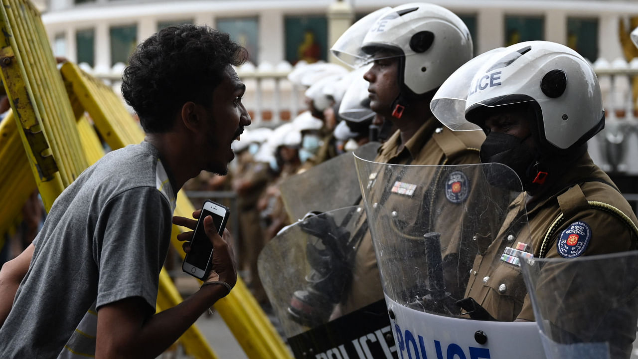 A demonstrator facing police personnel guarding the Presidential secretariat office in Colombo on July 22, 2022. Credit: AFP Photo