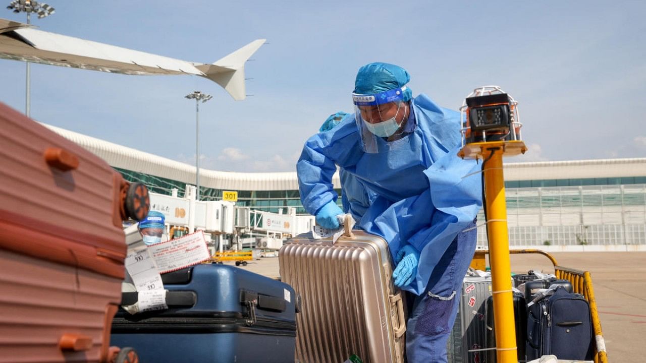 Workers transports luggage on airport tarmac in Wuhan. Credit: Reuters Photo
