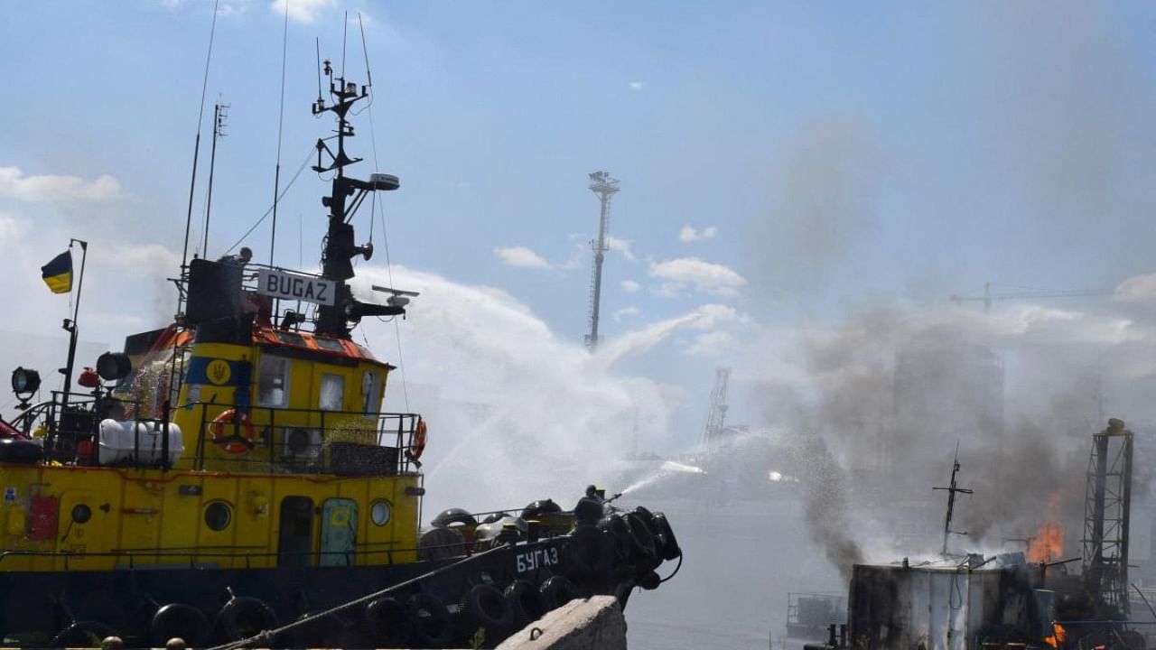 A handout image made available by the Odessa City Council Telegram channel on July 24, 2022, shows Ukrainian firefighters battling a fire on a boat burning in the port of Odessa after missiles hit the port on July 23, 2022. Credit: AFP Photo
