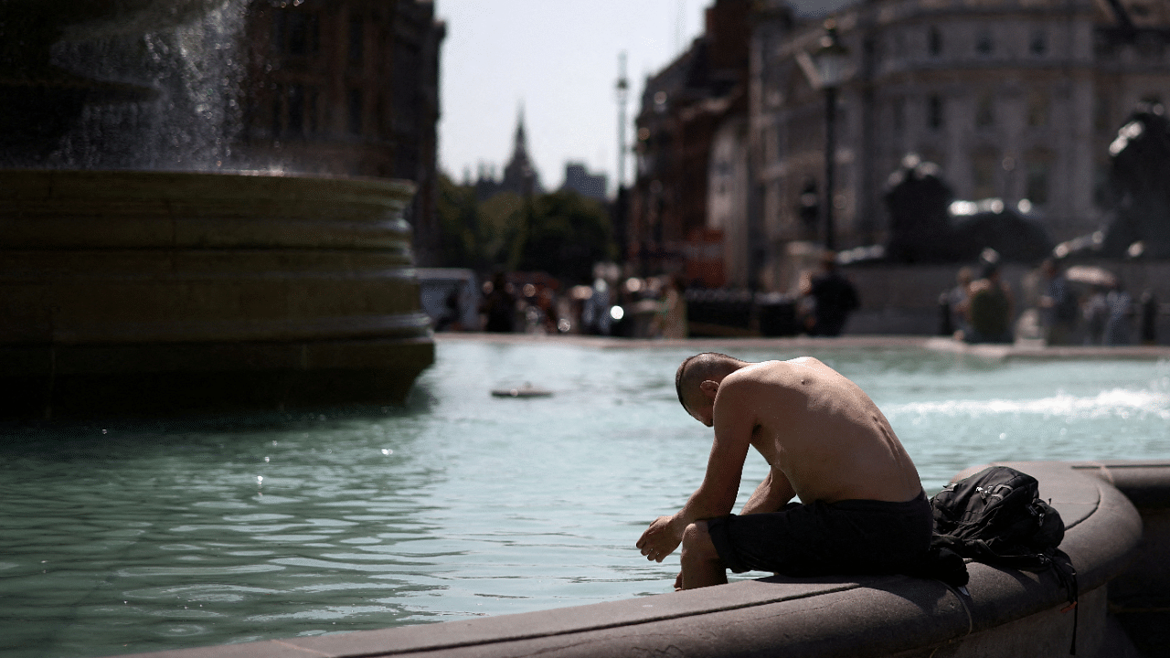 A man cools off in a water fountain during a heatwave, at Trafalgar Square in London, Britain. Credit: Reuters Photo