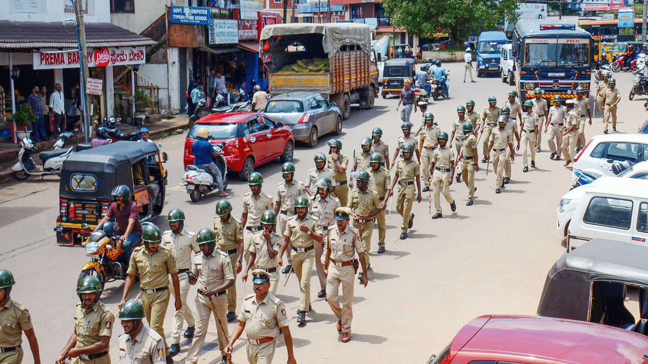 Police personnel take out a flag march in Puttur on Thursday. PTI Photo