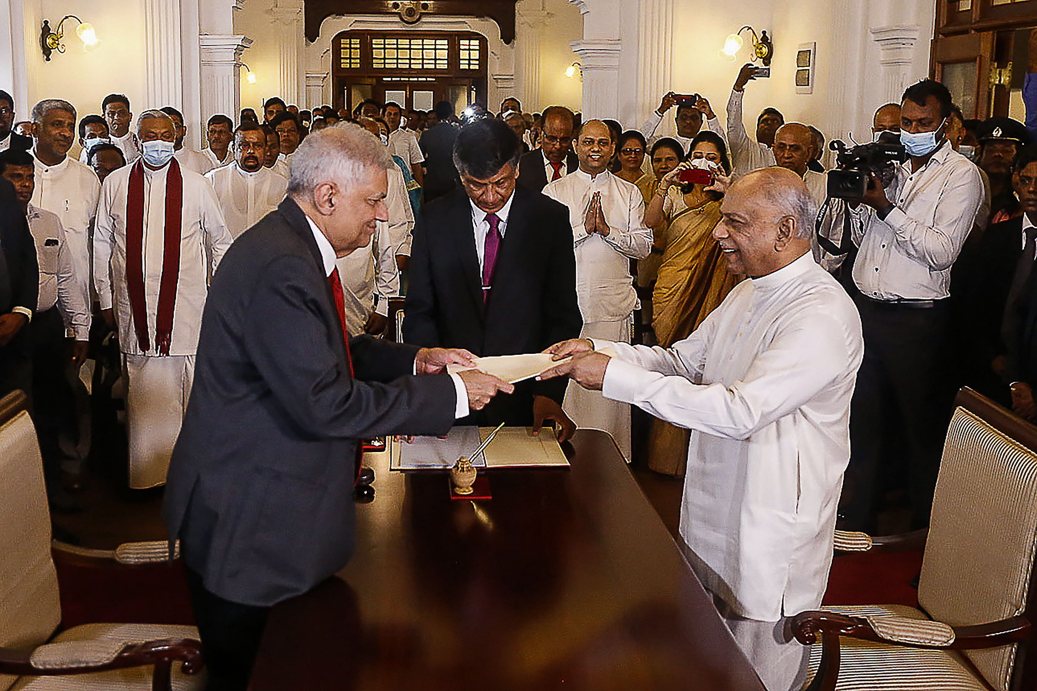 Sri Lakan President Ranil Wickremesinghe (L) swears in Dinesh Gunawardena (R) as Sri Lanka's new Prime Minister, at the prime minister office in Colombo on July 22. Credit:  AFP Photo