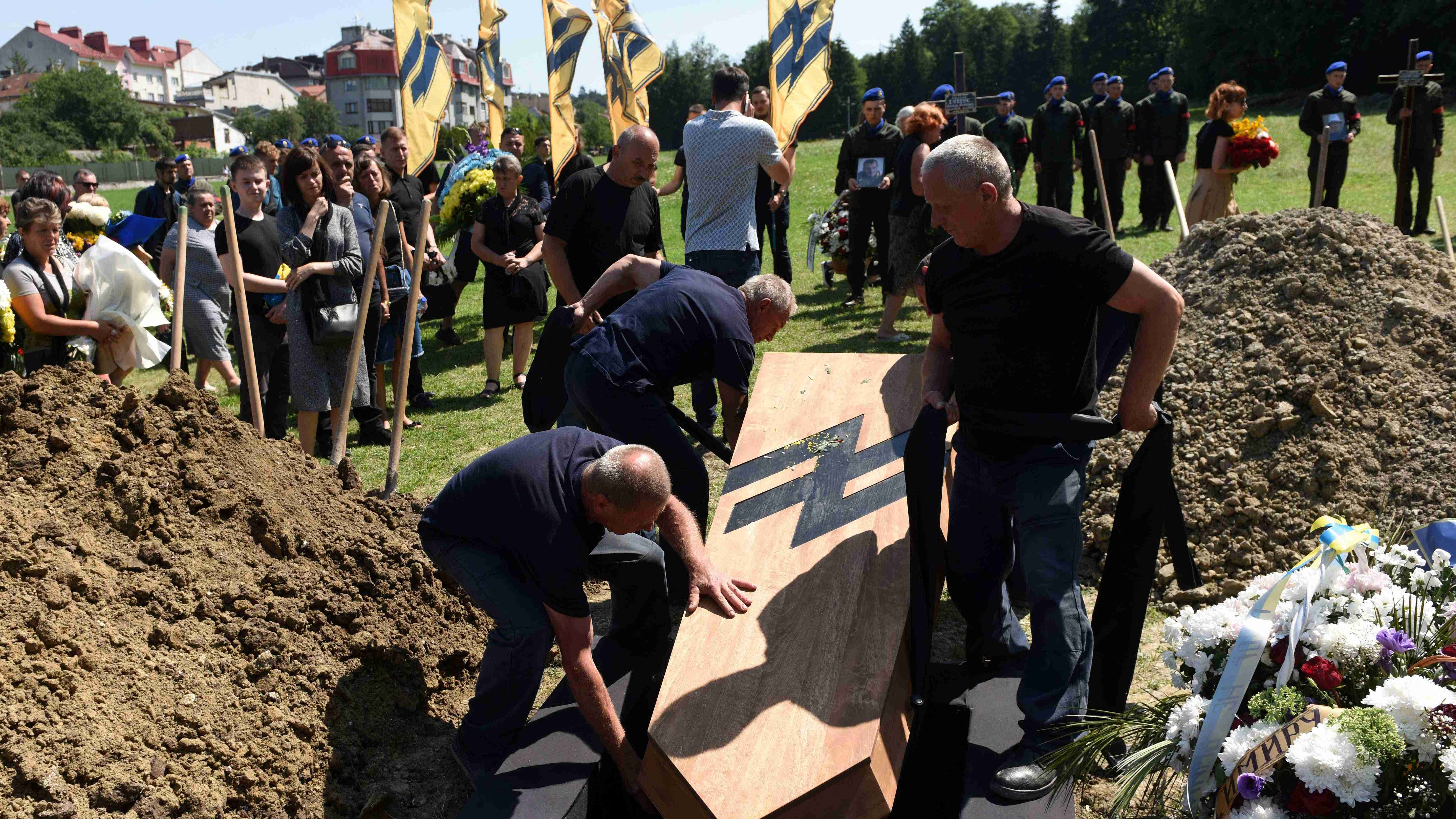 People attend the burial of the coffin of Vasyl Sushchuk, a serviceman of the Azov regiment. Credit: AFP Photo