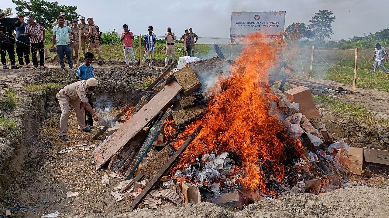 Flames rise from burning illegal narcotics, seized from various operations, during a mass drugs disposal programme organised by Guwahati's Police Commissionerate, in Kamrup district, Assam. Credit: PTI Photo