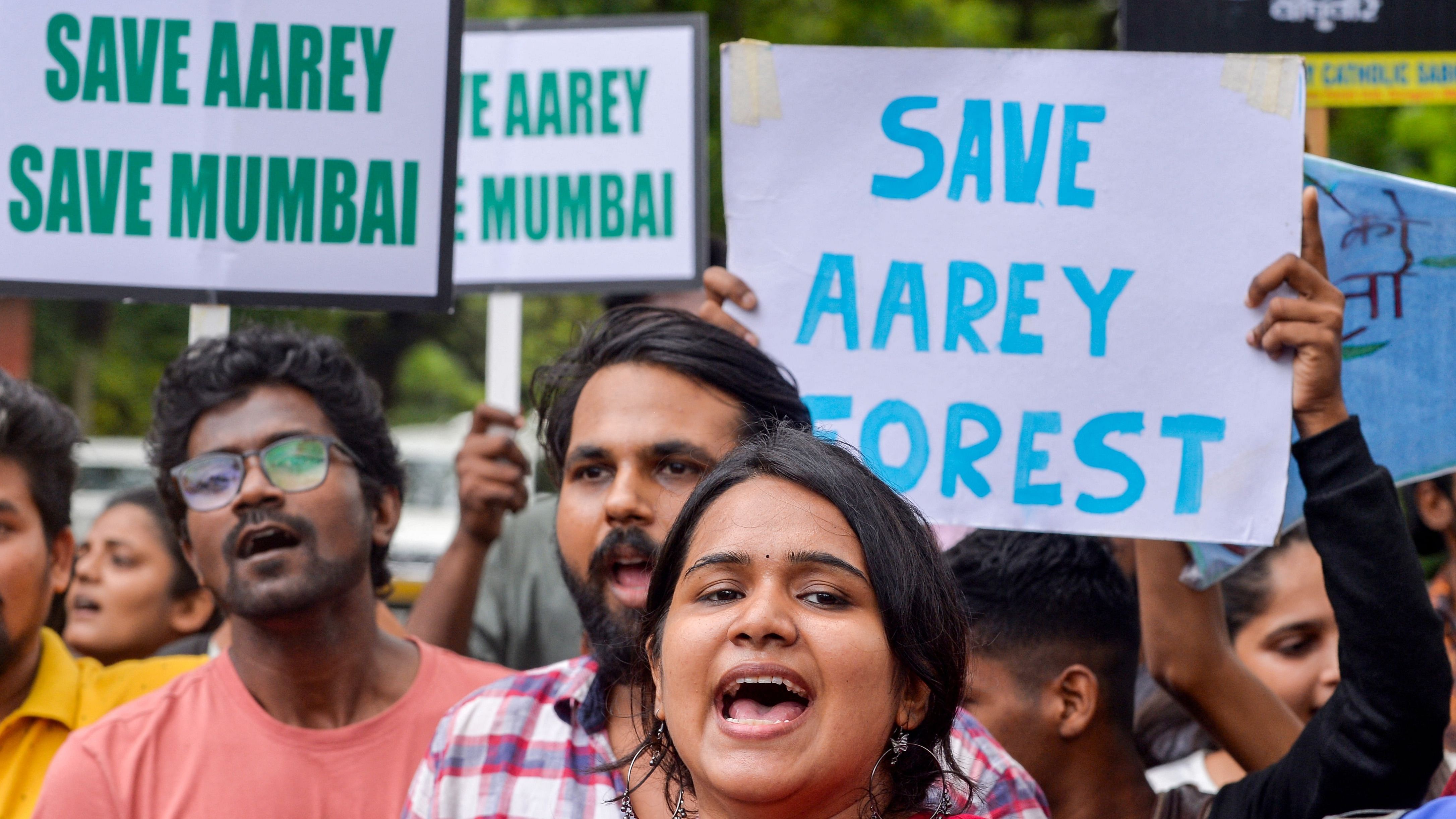 People shout slogans as they hold posters during a protest after the government re-approved of constructing a metro railway train car shed at the Aarey forest. Credit: AFP Photo