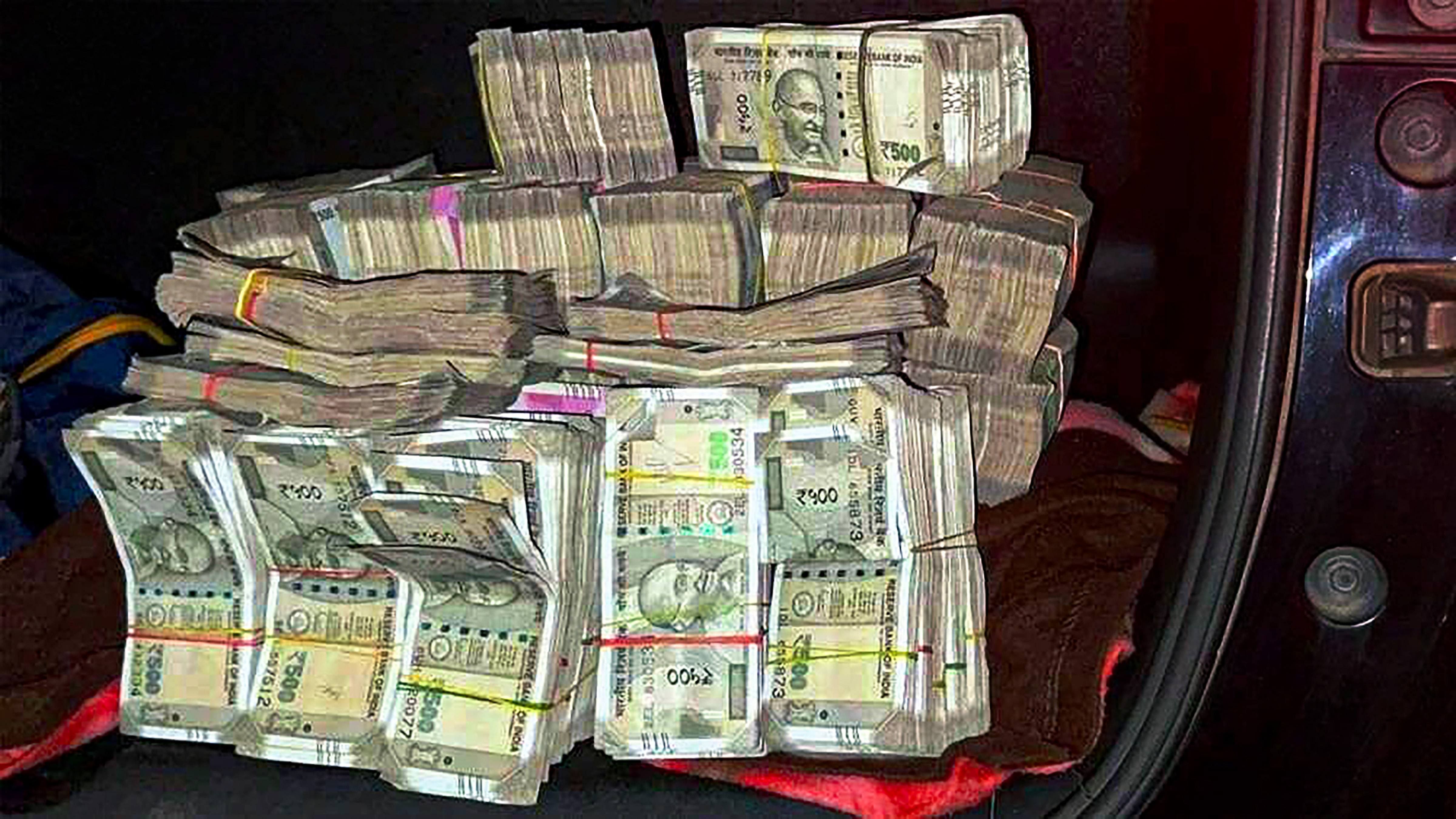 Huge amount of cash which was found in a vehicle in which three Jharkhand Congress MLAs Irfan Ansari, Rajesh Kachhap and Naman Viksal Kongadi, were traveling, at Ranihati in Howrah district. Credit: PTI File Photo