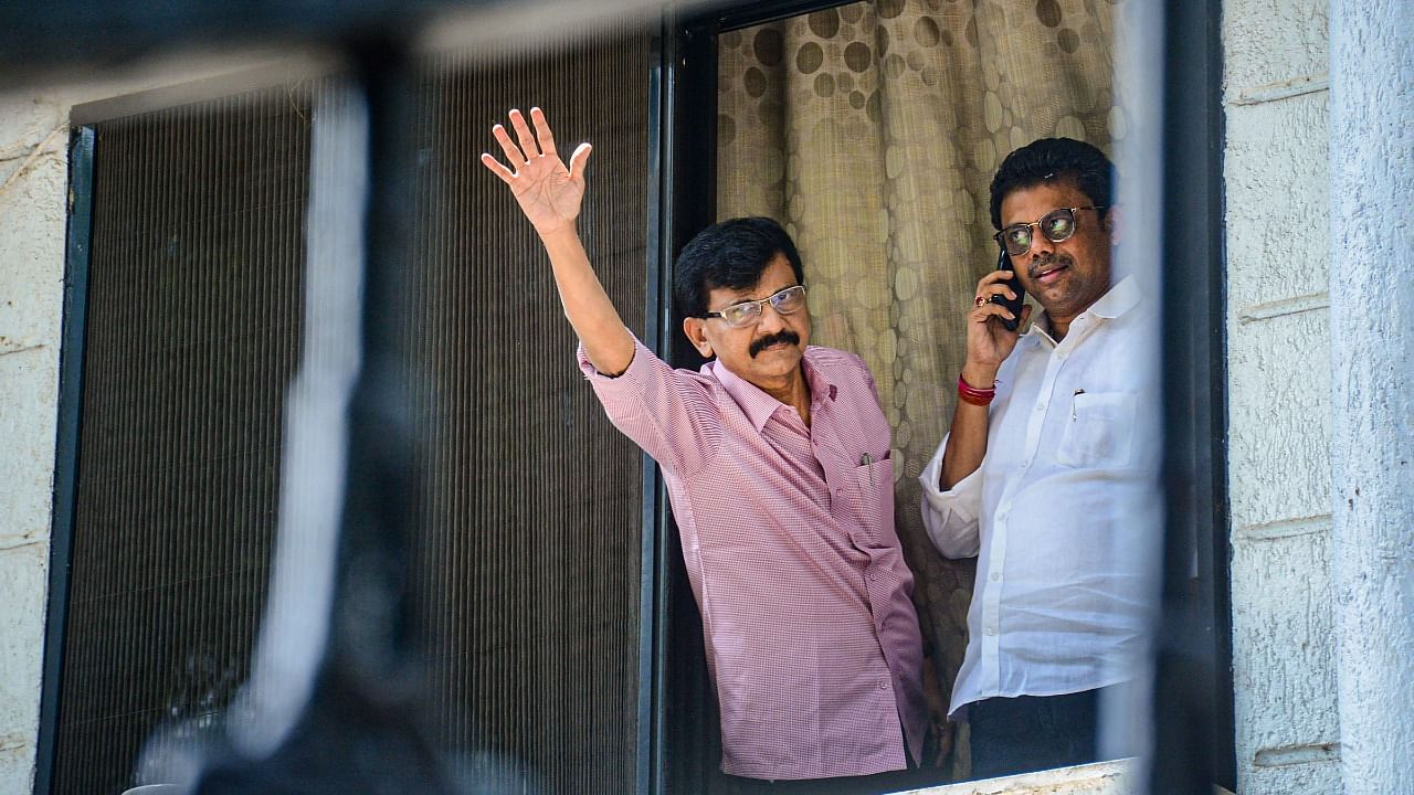 Shiv Sena MP Sanjay Raut waves at his supporters who gathered outside his residence after his premises were raided by ED officials, in Mumbai. Credit: PTI Photo