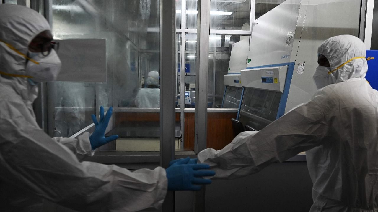 Technicians wearing personal protective equipment (PPE) suits are seen inside a molecular laboratory facility set up to test for the monkeypox disease. Credit: AFP Photo