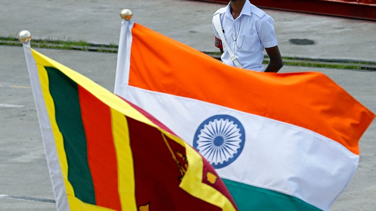 A Navy officer stands in front of India's and Sri Lanka's national flags as Indian Coast Guard Ship Shoor is in the Colombo port during its visit in Colombo. Credit: Reuters Photo