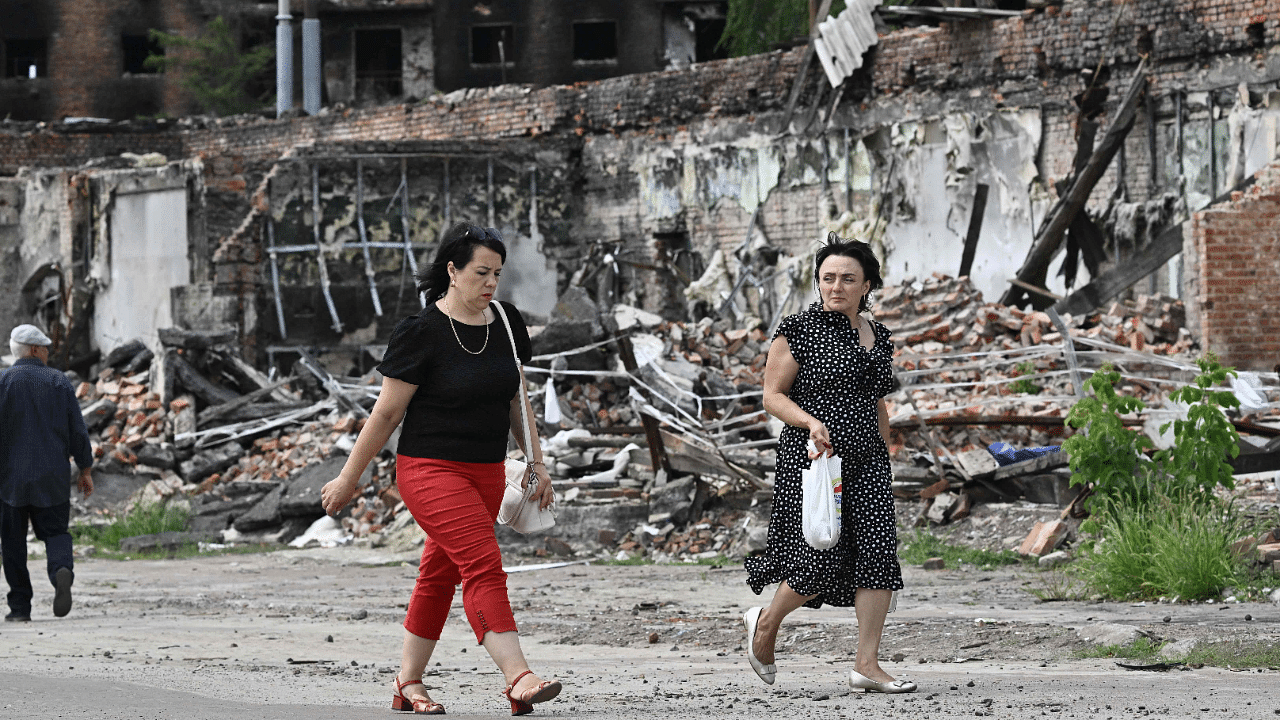 Pedestrians walk past destroyed buildings in the city of Trostyanets, Sumy region on August 1. Credit: AFP Photo