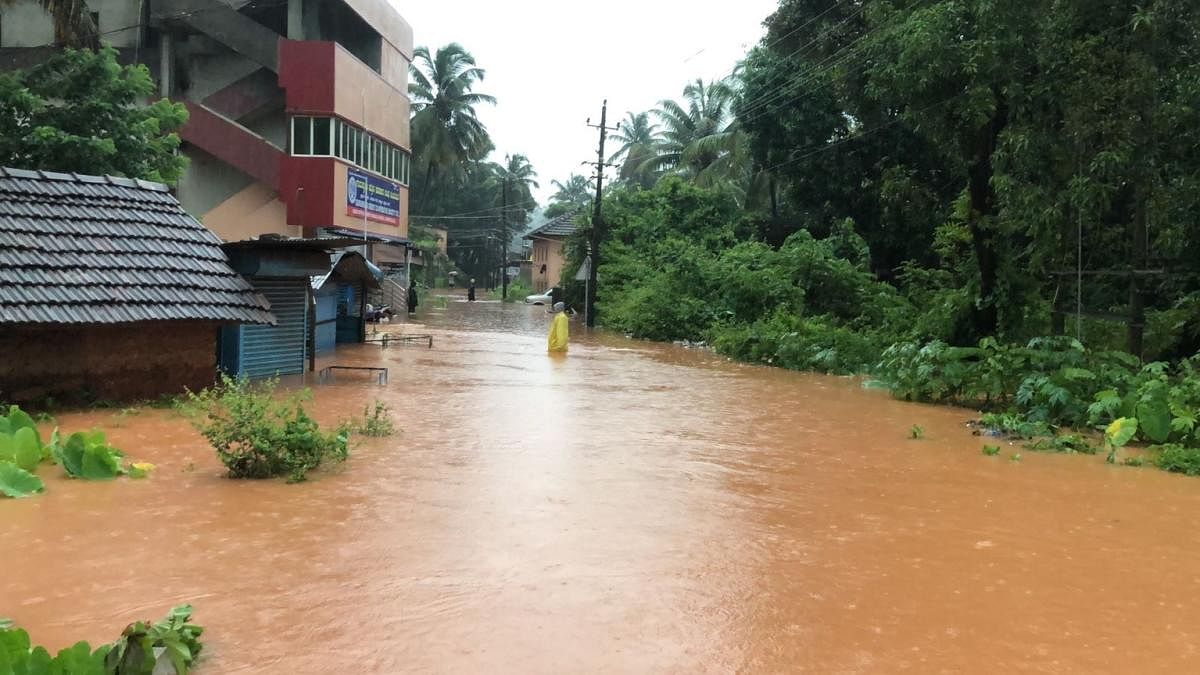 A flooded road in Bhatkal, Uttara Kannada district, following heavy rains late on Sunday night. (inset) Rainwater enters a house. Credit: DH Photo