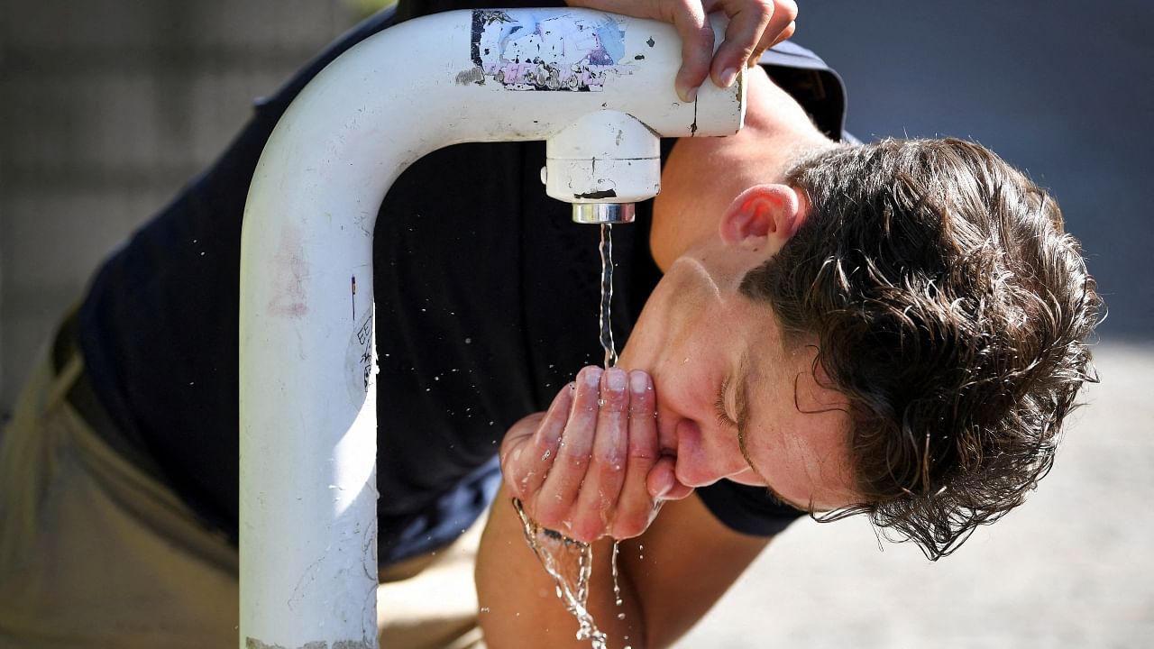 A man drinks water from a public drinking establishment during a heatwave in Nijmegen, Netherlands. Credit: Reuters Photo