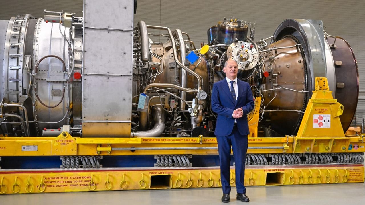 German Chancellor Olaf Scholz stands in front of a turbine of the Nord Stream 1 pipeline during a visit on August 3, 2022 at the plant of Siemens Energy in Muelheim an der Ruhr. Credit: AFP Photo