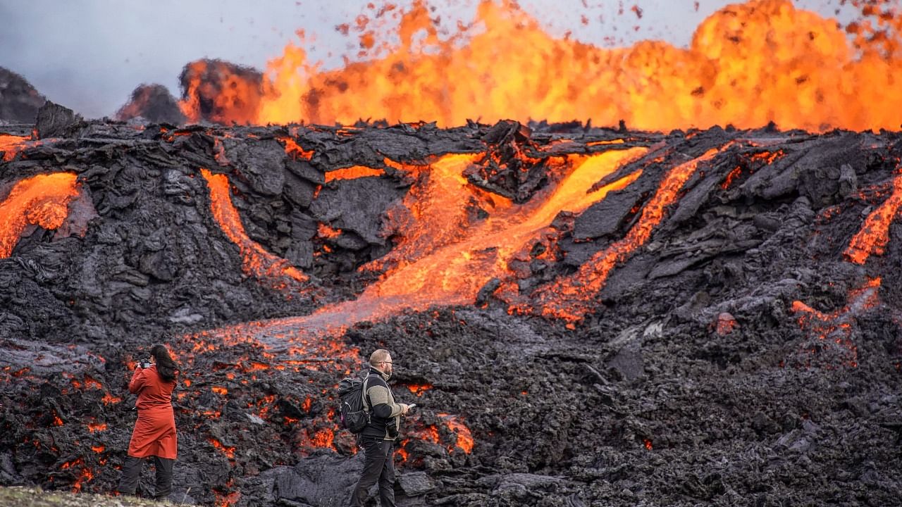 People look at the lava flowing on Fagradalsfjall volcano in Iceland. Credit: AP Photo