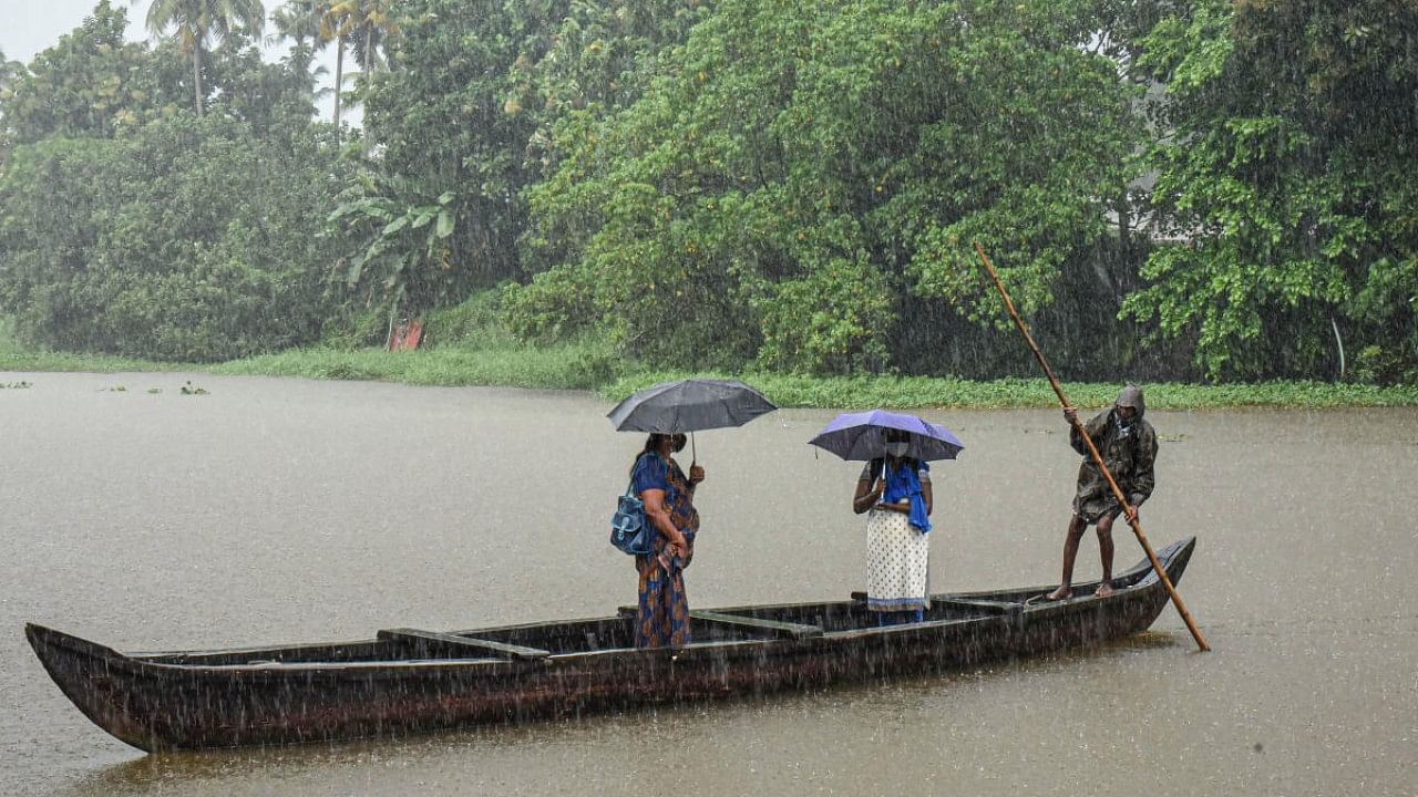 A boatman ferries passengers ashore during monsoon rains, in Kochi. Credit: PTI Photo