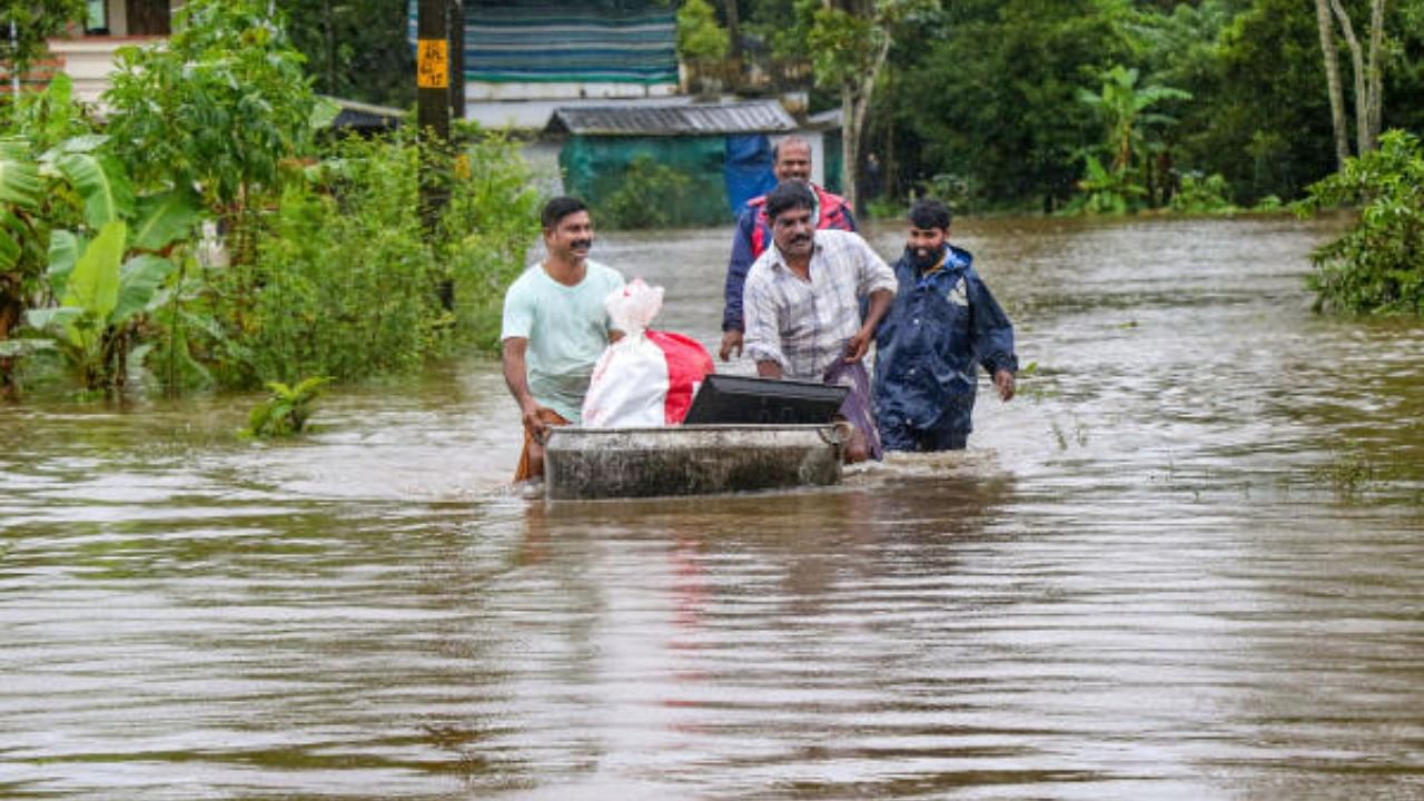 Locals wade through a flood affected area following heavy monsoon rains, in Thrissur district, Thursday, Aug. 4, 2022. Credit: PTI Photo