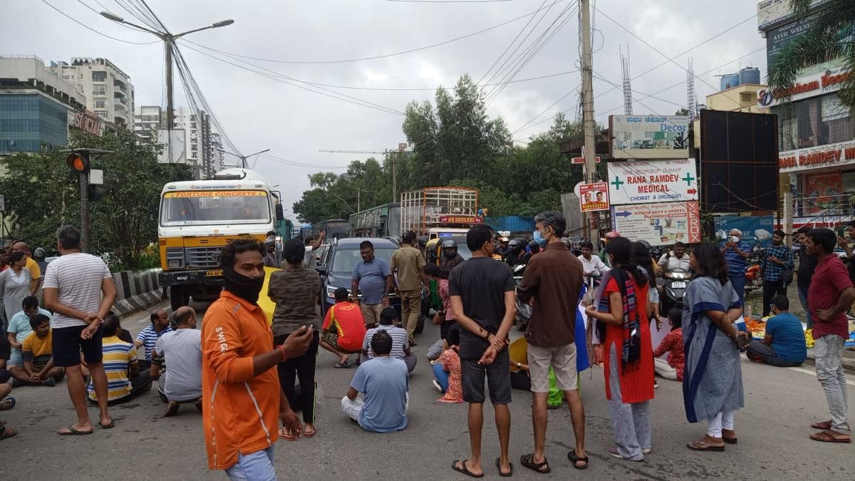 Residents of Rainbow Drive, Sarjapur Road, block the road to protest the flooding of their neighbourhood on Thursday. Credit: DH Photo