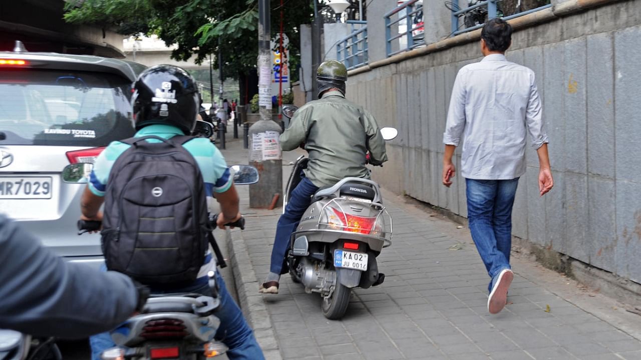 A two-wheeler rider on the footpath near General KS Thimayya Road in Bengaluru. Credit: DH File Photo/Pushkar V