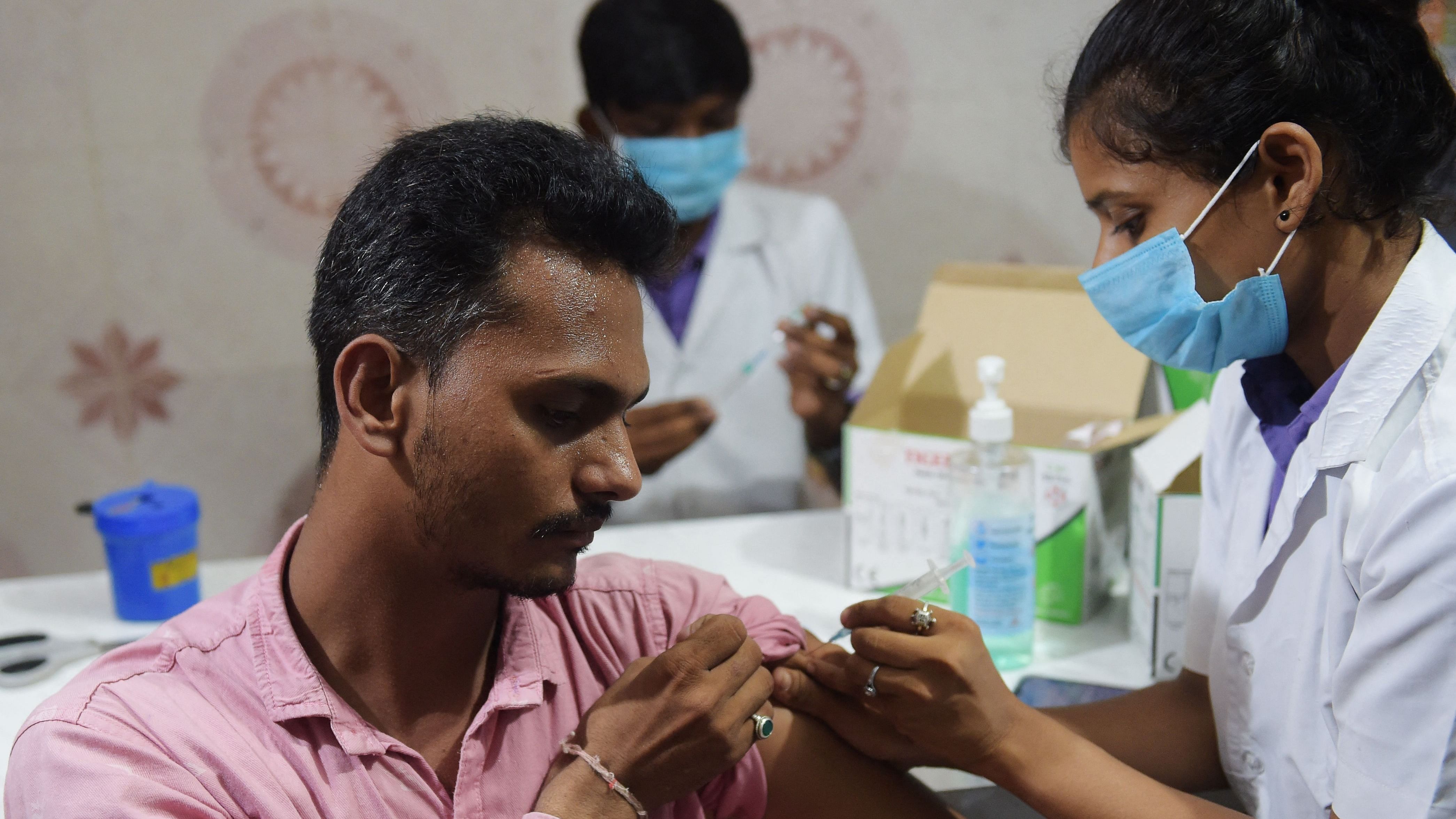 A health worker administers a booster shot. Credit: AFP Photo