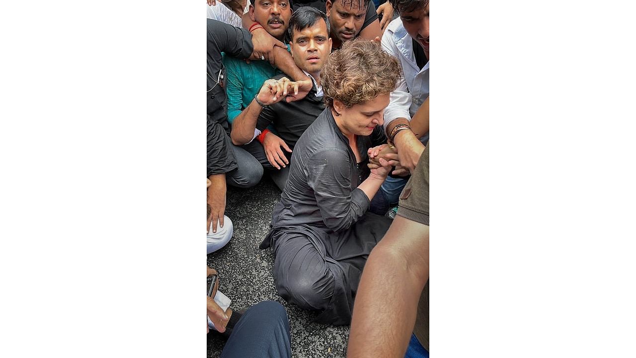Congress leader Priyanka Gandhi, wearing black clothes, sits on the road during a protest march as part of party’s nationwide protest over price rise, unemployment and GST hike on essential items, in New Delhi. Credit: PTI Photo